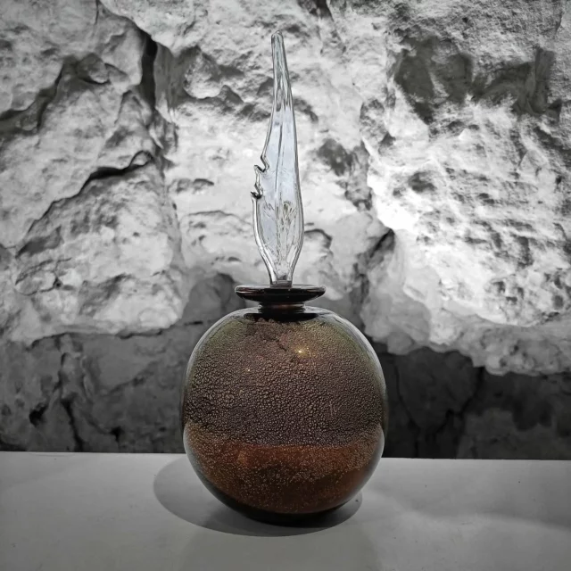 Flacon stylé cherche étagère de caractère.Corps en verre noir à la feuille d'or, bouchon plume en verre ... Un combo qui fait mouche. Idéal pour les amateurs d’objets raffinés, les alchimistes du dimanche et ceux qui pensent que le bon goût, c'est comme la poussière : ça se pose partout (mais en plus joli).⚠️ Ne s’utilise pas comme plume pour écrire. À moins d’aimer les défis.